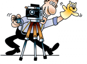 mężczyzna stojący za aparatem fotograficznym, tymający kukiełkę w ręku